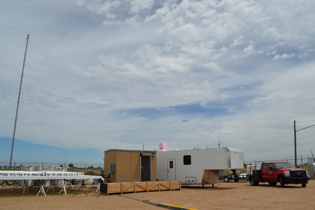 The SSEC SPARC trailer at the Boulder Atmospheric Observatory (BAO), with the BAO tower in the distance and a NASA P3 airborne observatory above.