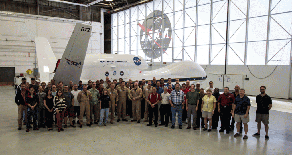 A group shot of those involved in the Hurricane and Severe Storm Sentinel (HS3) field campaign. One of two Global Hawk aircraft integral to the mission is visible in the background. Photo Credit: NASA.